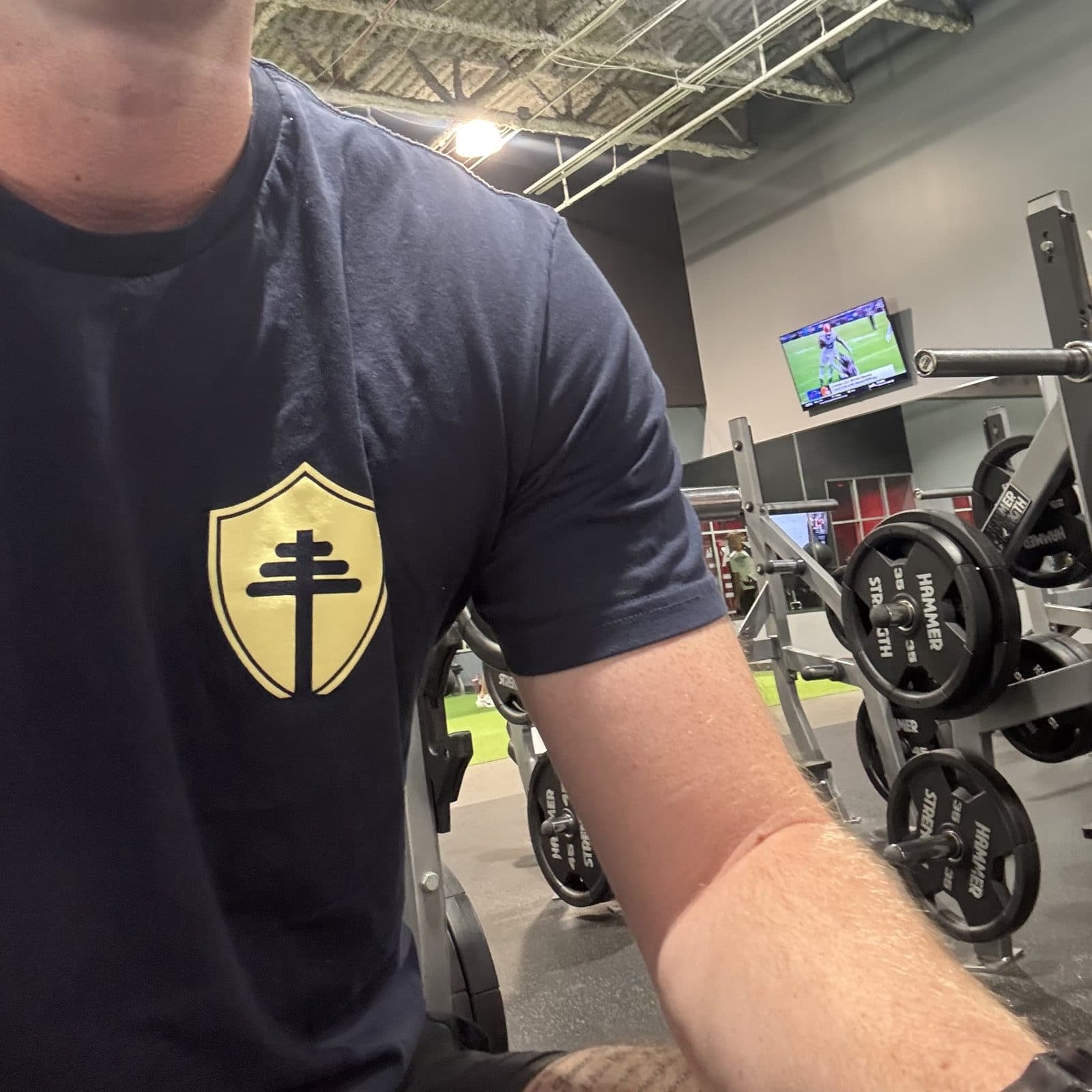 Navy Iron Chapel shield tee worn between sets in the gym